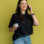 Mitarbeiterin Planungsbüro Projekt-HLS mit Kaffeetasse vor gelbem Hintergrund