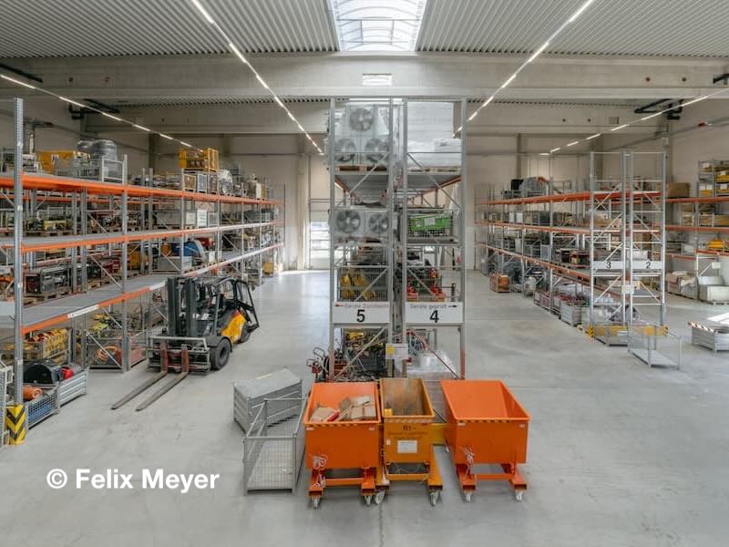 Innenansicht des Logistikzentrums Markgraf in Kemnath mit Hochregallager, Gabelstapler und sortierten Lagerplätzen.