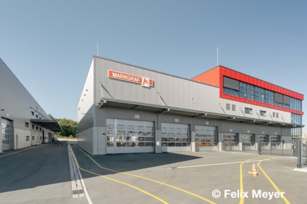 Außenansicht des Logistik- und Mobilitätszentrums Markgraf in Kemnath mit Firmenlogo und moderner grauroter Fassade.